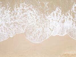 Drone view ocean foam. Transparent clear wave coming on sandy beach aerial shot. photo