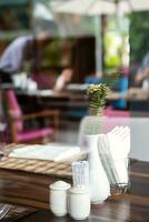 Hotel restaurant space with tables set for dinner at luxury resort, view through by window. photo