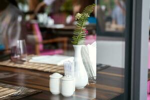 Hotel restaurant space with tables set for dinner at luxury resort, view through by window. photo