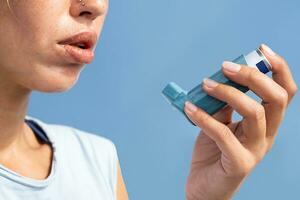 mujer utilizando asma inhalador durante asma ataque. foto