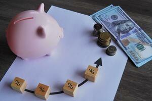 Top view image of money, piggy bank and increase percentage icon. Finance, interest rate concept. photo