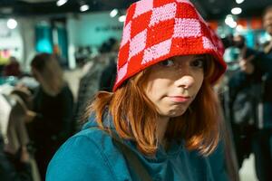 Adorable Teenage Girl in Funny Red Knitted Hat, Red-Haired Portrait photo