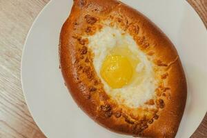 tentador khachapuri, clásico georgiano huevo y queso pan, presentado en un encantador café foto