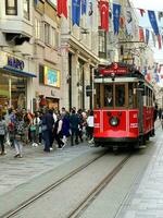 dieciséis de abril 2023 - Estanbul, Turquía - ciudad vida, el personas y famoso rojo tranvía en istiklal peatonal calle foto