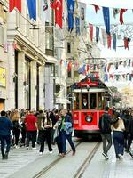 dieciséis de abril 2023 - Estanbul, Turquía - ciudad vida, el personas y famoso rojo tranvía en istiklal peatonal calle foto