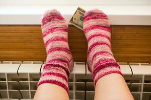 Feet in warm winter socks warm up on the radiator. photo