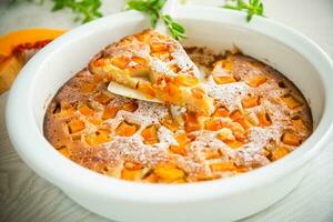 sweet pumpkin pie with pumpkin slices in a ceramic mold photo