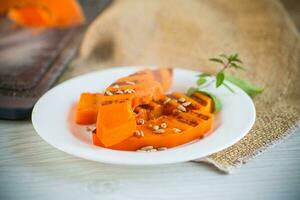 sweet baked grilled pumpkin with seeds in a plate photo