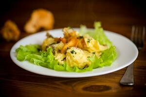 fried omelet with forest mushrooms chanterelles, on table photo