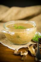 hot homemade vegetable vegetarian soup with dried mushrooms in a glass bowl photo