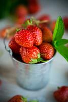 red ripe natural strawberries on a wooden table photo