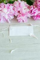 several branches of blooming pink peonies on a wooden table photo