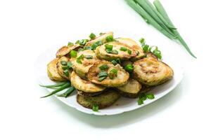 fried zucchini in circles with fresh herbs in a plate isolated on white photo