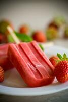 homemade strawberry ice cream on a stick made from fresh strawberries in a plate photo