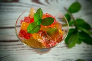 de colores dulce Fruta jalea en un vaso vaso foto