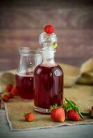 sweet cooked strawberry syrup in a glass decanter photo