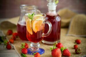 refreshing cool strawberry lemonade with lemon, ice and mint in a glass photo