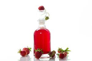 sweet cooked strawberry syrup in a glass decanter photo