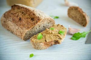 homemade liver pate with bread on a wooden table photo