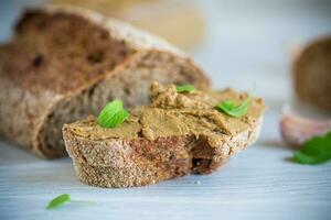 homemade liver pate with bread on a wooden table photo