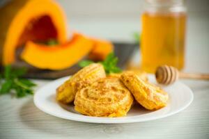 sweet lush pumpkin pancakes with honey in a plate photo