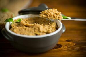 homemade meat pate in a ceramic bowl on a wooden table photo