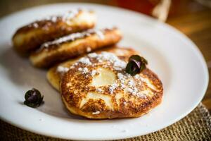 sweet fried cottage cheese pancakes in a plate photo