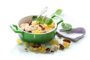 cooked boiled sweet oatmeal with nuts and candied fruits in a bowl photo