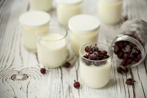 Homemade sweet yogurt with frozen berries in a glass photo