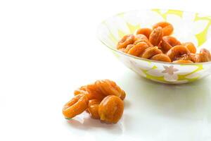 delicious dried apricots in a bowl on white background photo