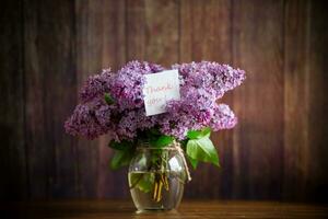 bouquet of beautiful spring flowers of lilac on the table photo