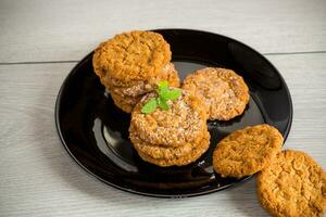 cooked sweet oatmeal cookies on wooden table photo