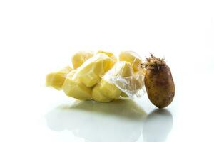 pelado patatas cerrado en un vacío bolso y antiguo brotado patatas foto