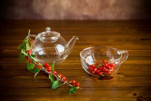 Branch with ripe red goji berry on wooden table photo