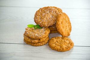 cooked sweet oatmeal cookies on wooden table photo