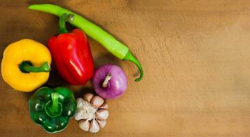 Natural fresh organic Bell pepper red green yellow, hot peppers, shallot and garlic on Cutting Board isolated on white background photo