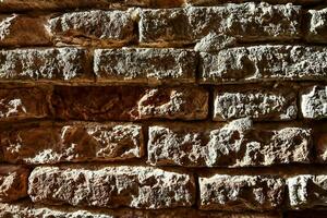 a close up of a brick wall with some small stones photo