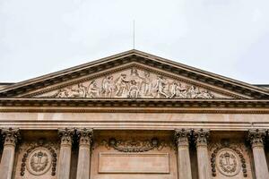 the front of a building with statues on it photo