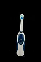 un azul y blanco eléctrico cepillo de dientes en un negro antecedentes foto
