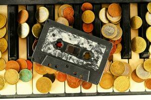 a cassette and coins on a piano keyboard photo