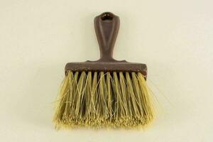 a brush with a brown handle on a white surface photo