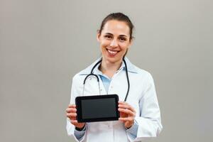 Portrait of beautiful female doctor showing digital tablet. photo