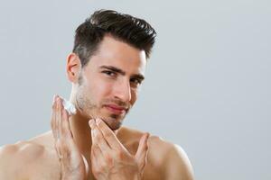 Man applying shaving cream photo