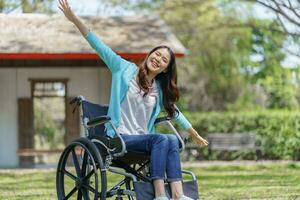 joven asiático mujer en silla de ruedas con positivo pensamiento. foto