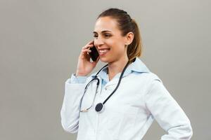 Beautiful female doctor using mobile phone. photo