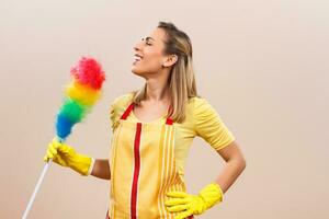 Beautiful housewife is singing while cleaning. photo