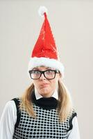 Nerdy woman with a santa hat thinking photo