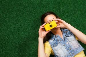 mujer acostado abajo en el césped y fotografiando foto