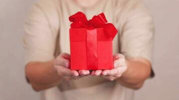 Cropped woman giving or receiving a gift with a red bow. She shows a gift slow motion video footage