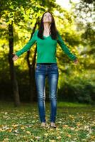 Woman with arms outstretched enjoys in the park photo